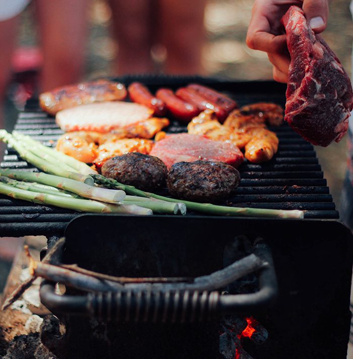 A grill with meat and vegetables on it.